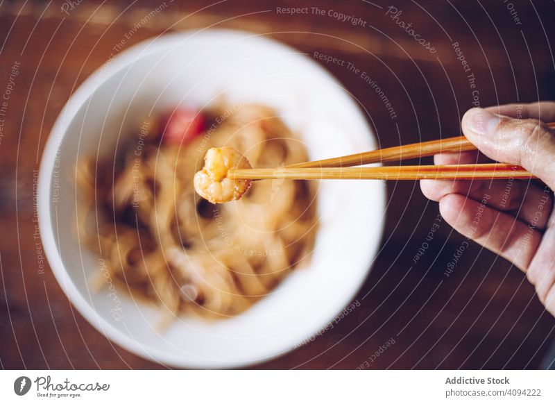 Gesichtslose Person isst Abendessen mit Stäbchen Granele Essstäbchen Nudeln Lebensmittel Mahlzeit Küche Speise Krabbe Asiatische Küche Meeresfrüchte