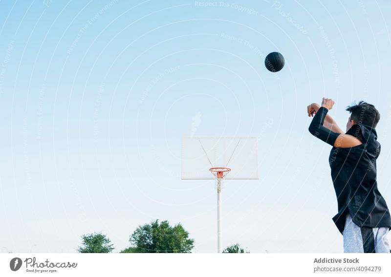 Junger Mann spielt auf gelbem Basketballfeld im Freien. Athlet Konkurrenz Sportgerät Erwachsener Erholung Aktion Ball Porträt aktiv Aktivität Asphalt sportlich