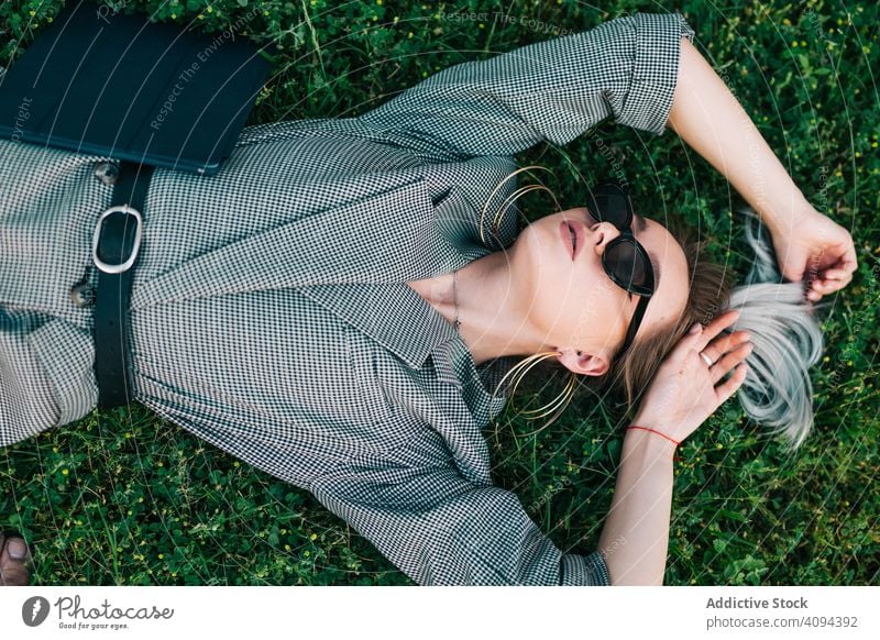 Frau mit Tablette im schicken Anzug im Gras liegend Geschäftsfrau ruhen Lügen grün Pause benutzend Erholung stylisch trendy Business Mitteilung Manager Karriere