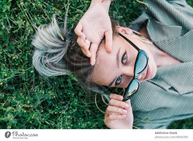 Frau in elegantem Anzug und Sonnenbrille im Gras liegend Geschäftsfrau ruhen Lügen grün Pause Erholung stylisch trendy Business Manager Karriere Unternehmer