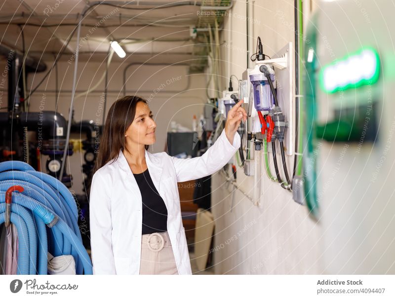 Sicherheitsinspektor, der elektrische Geräte überprüft Inspektor Industrie Einrichtung Elektrizität Schaltfläche Presse Frau Job professionell Beruf beschäftigt