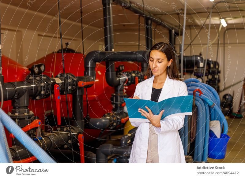 Sicherheitsinspektor macht sich Notizen im Tagebuch Inspektor Industrie Einrichtung prüfen schreiben Journal Hinweis Röhren System Frau Job professionell Beruf