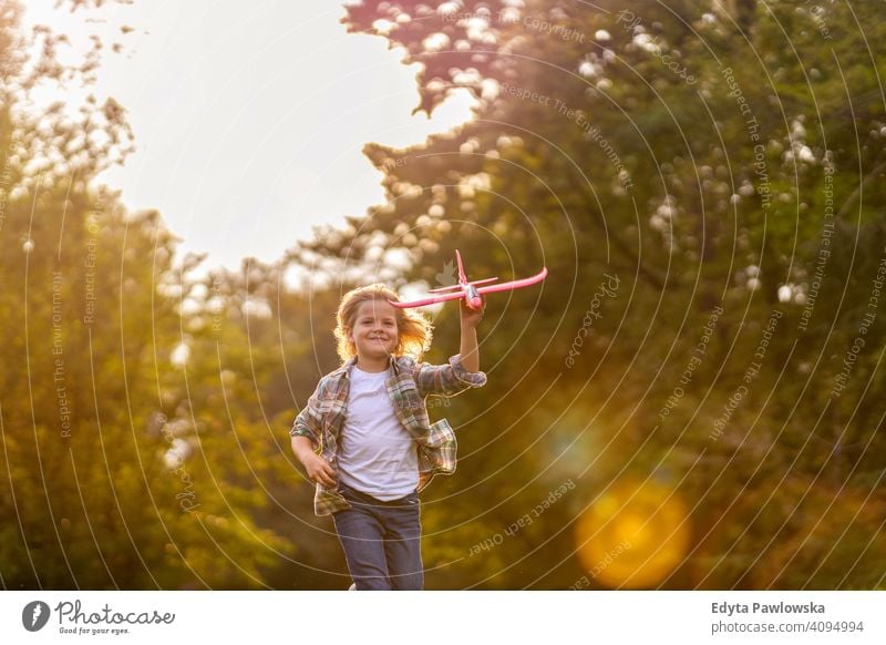 Kleiner Junge spielt mit Spielzeug Flugzeug im Park Menschen Kind kleiner Junge Kinder Kindheit im Freien lässig niedlich schön Porträt Lifestyle elementar