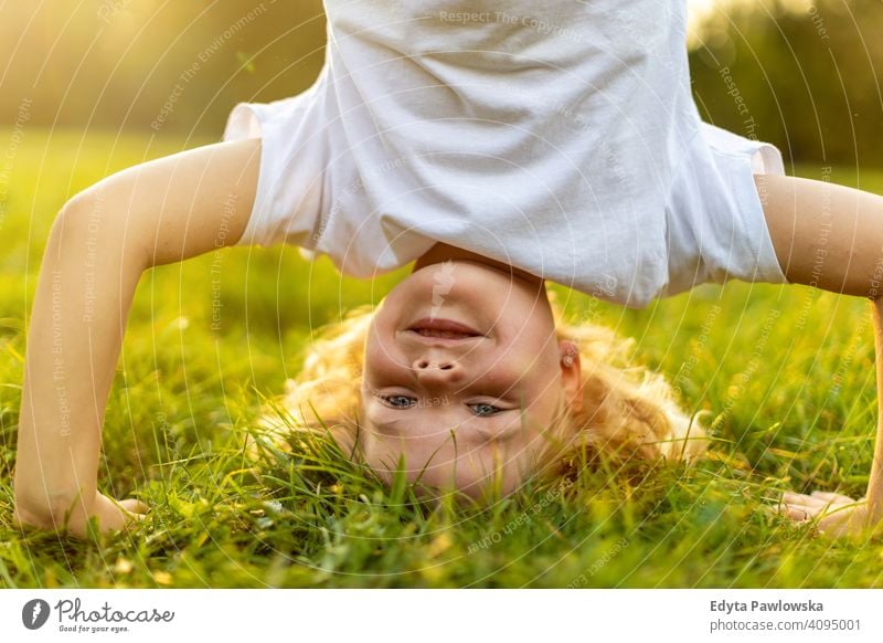 Kind macht Kopfstand im Park Handstand auf den Kopf gestellt trainiert. Sport Gesundheit Vitalität aktiv Menschen Junge kleiner Junge Kinder Kindheit im Freien