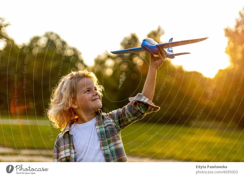 Kleiner Junge spielt mit Spielzeug Flugzeug im Park Menschen Kind kleiner Junge Kinder Kindheit im Freien lässig niedlich schön Porträt Lifestyle elementar