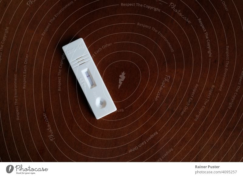 Coronavirus (COVID-19) Antigen-Schnelltest mit negativem Ergebnis auf einem Holztisch Bio-Gefahr Biogefahrensymbol Korona Corona-Virus covid-19 Infektion