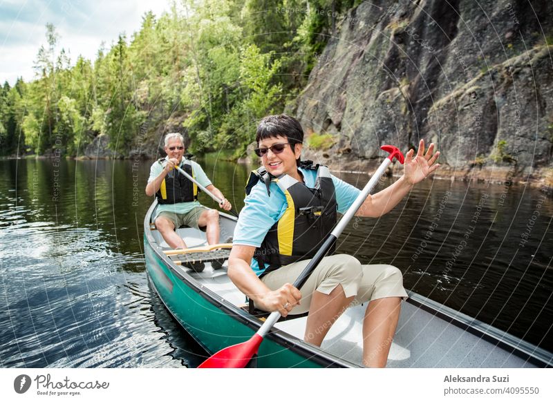 Glückliches reifes Paar in Rettungswesten Kanufahren im Waldsee. Sonniger Sommertag. Touristen, die in Finnland reisen und Abenteuer erleben. aktiv Aktivität