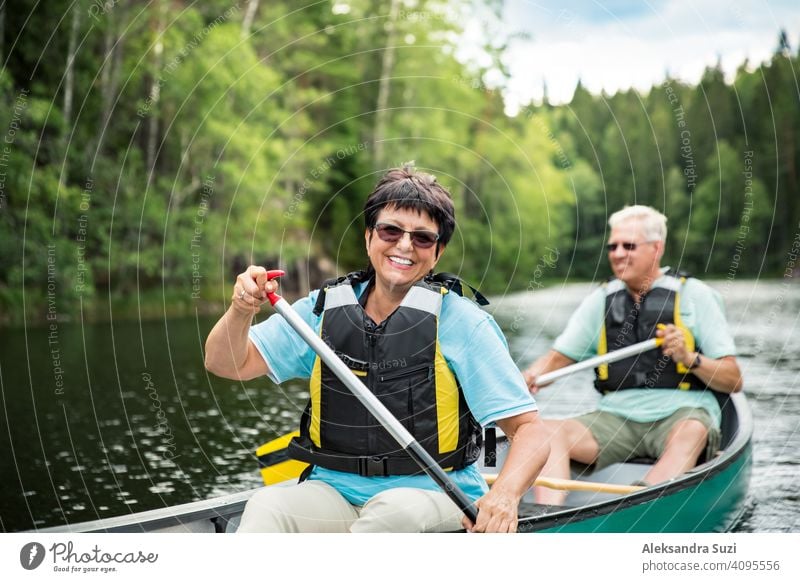 Glückliches reifes Paar in Rettungswesten Kanufahren im Waldsee. Sonniger Sommertag. Touristen, die in Finnland reisen und Abenteuer erleben. aktiv Aktivität