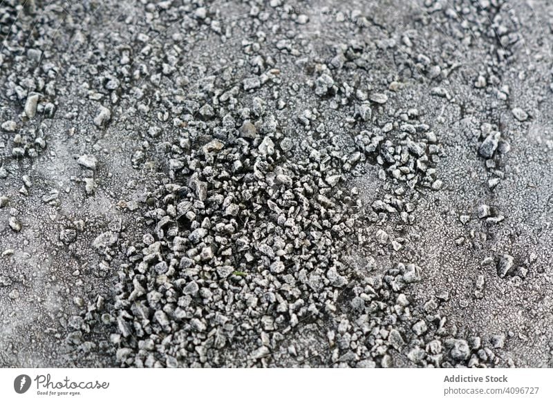 Ein Haufen gefrosteter Kieselsteine auf dem Boden Frost Textur klein gefroren Felsen grau eisig Schnee natürlich abstrakt Kopfsteinpflaster dunkel Felsbrocken