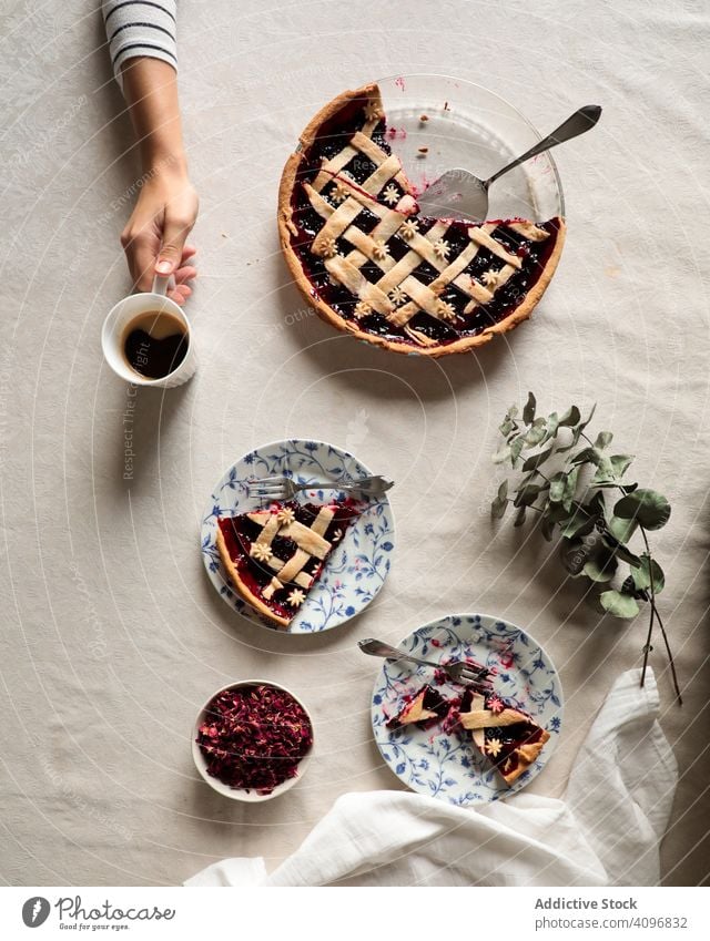 Gesichtslose Person genießt Kaffee mit selbstgebackenem Kuchen Pasteten lecker selbstgemacht Beeren serviert essen trinken genießen vorbereitet gekocht süß