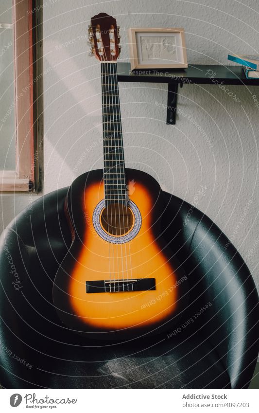 Akustische Gitarre auf schwarzem Lederstuhl akustisch Stuhl modern minimalistisch sehr wenige Instrument Regal Raum Innenbereich Musik Haus heimwärts Hobby