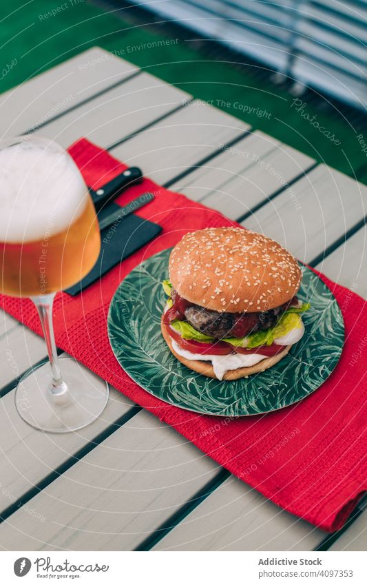 Cheeseburger mit Kopfsalat und Tomate Burger Brötchen klassisch ungesund Salat Tisch Lebensmittel Mahlzeit Zwiebel Rindfleisch lecker grillen Grillrost Snack