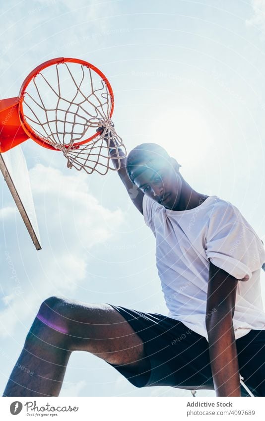 Afroamerikanischer Sportler hängt auf Basketball-Runde Ball tretend Netz Slam Dunk Spiel Spieler Stadion Spielen Sportbekleidung Aktivität Feld männlich