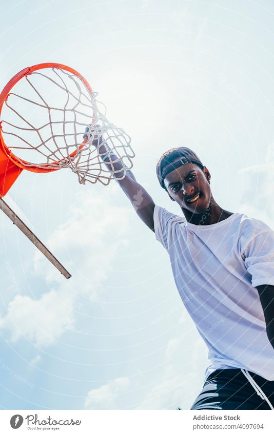 Afroamerikanischer Sportler hängt auf Basketball-Runde Ball tretend Netz Slam Dunk Spiel Spieler Stadion Spielen Sportbekleidung Aktivität Feld männlich