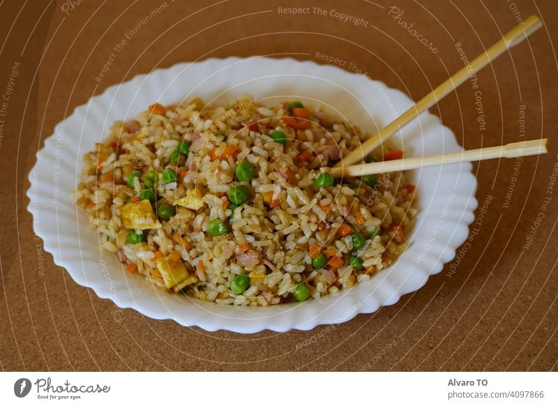 Delcious Special Gebratener Reis in einer weißen Schale und asiatische Essstäbchen Essen zubereiten Saucen Fleisch Ei speziell China Abendessen Teller gekocht