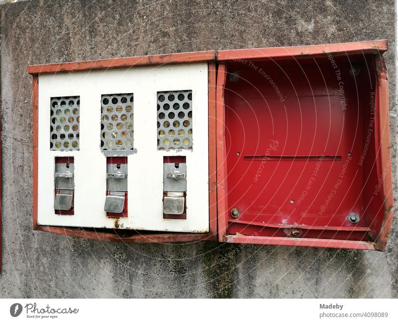 Ramponierter alter roter Kaugummiautomat auf grauer Hauswand in Lemgo bei Detmold in Ostwestfalen-Lippe Automat Rot Blech zerdellt eingedellt zerstört kaputt