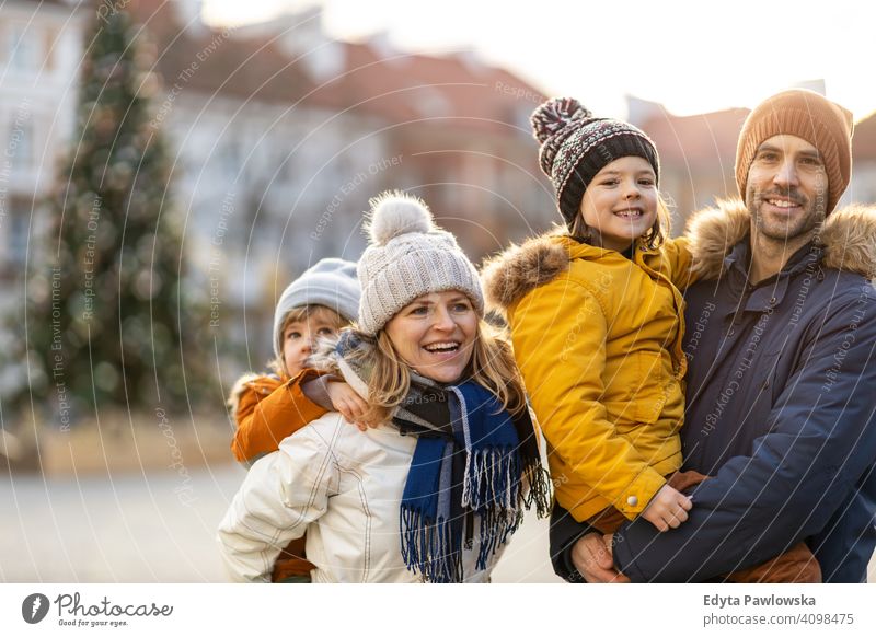 Glückliche junge Familie mit Spaß im Freien während Weihnachten Winter Mann Herbst Vater Frau Mutter Eltern Verwandte Sohn Jungen Kinder Partnerschaft