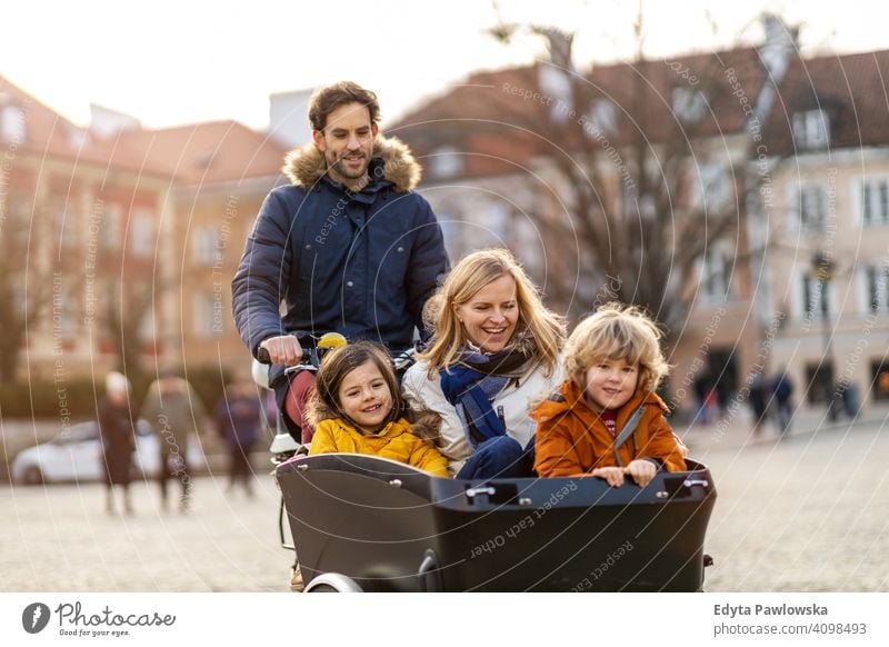 Junge Familie fahren in einem Lastenfahrrad zusammen Lastenrad Fahrrad Fahrradfahren Verkehr Dreirad Gesundheit aktiv Zyklus Radfahren modern