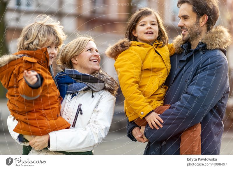 Junge Familie mit zwei Kindern in einer Stadt jung Winter Mann Herbst Vater Frau Mutter Eltern Verwandte Sohn Jungen Partnerschaft Zusammensein