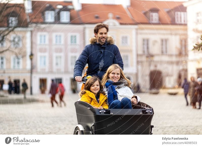 Junge Familie fahren in einem Lastenfahrrad zusammen Lastenrad Fahrrad Fahrradfahren Verkehr Dreirad Gesundheit aktiv Zyklus Radfahren modern