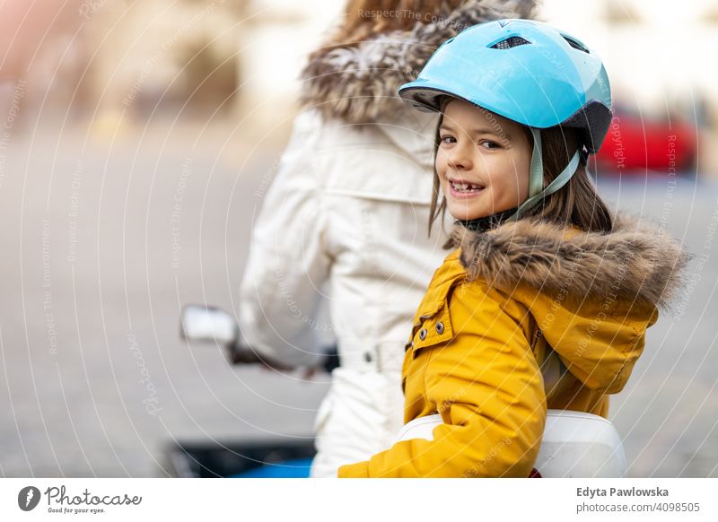 Junge Frau und ihr Sohn fahren mit dem Fahrrad in einer Stadt jung tragend Schutzhelm Fahrradfahren Winter Herbst Mutter Familie Eltern Verwandte Kind Kinder