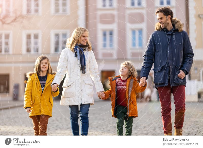 Junge Familie mit zwei Kindern in einer Stadt jung Winter Mann Herbst Vater Frau Mutter Eltern Verwandte Sohn Jungen Partnerschaft Zusammensein