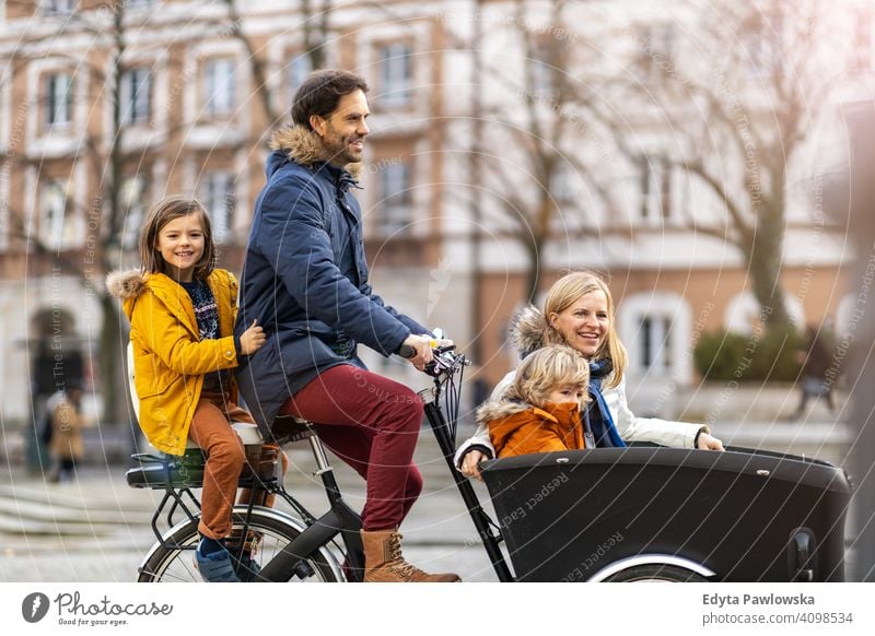 Junge Familie fahren in einem Lastenfahrrad zusammen Lastenrad Fahrrad Fahrradfahren Verkehr Dreirad Gesundheit aktiv Zyklus Radfahren modern