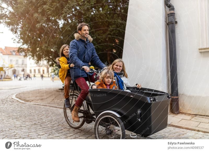 Junge Familie fahren in einem Lastenfahrrad zusammen Lastenrad Fahrrad Fahrradfahren Verkehr Dreirad Gesundheit aktiv Zyklus Radfahren modern