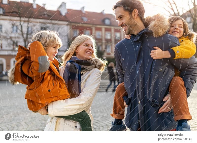 Junge Familie mit zwei Kindern in einer Stadt jung Winter Mann Herbst Vater Frau Mutter Eltern Verwandte Sohn Jungen Partnerschaft Zusammensein