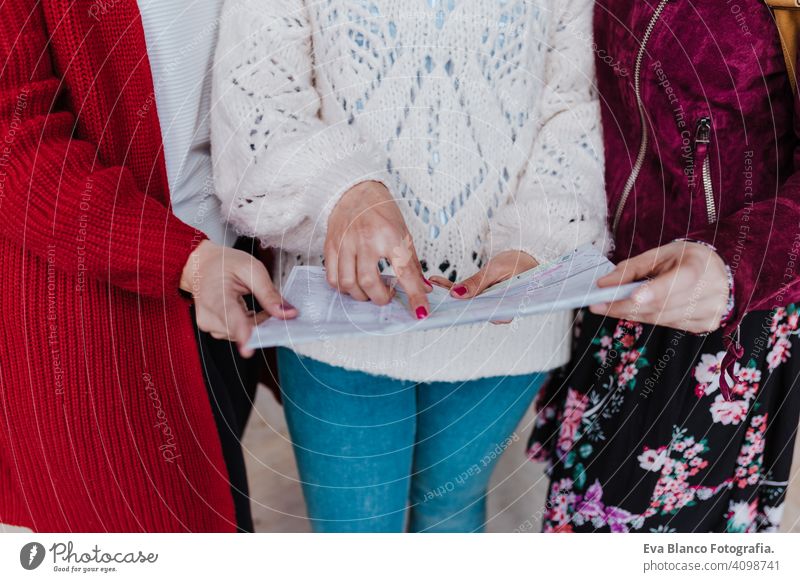 Nahaufnahme einer Gruppe von drei jungen kaukasischen Frauen am Bahnhof, die eine Karte lesen. Reisen und Freundschaft Konzept unkenntlich reisen Freunde