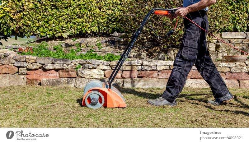 Gartenarbeit im Frühling. Vertikutieren, Rasen lüften im Garten zur Verbesserung der Rasenqualität im Frühjahr. männlich Arbeiter Mann Gärtner Bodenbelüftung