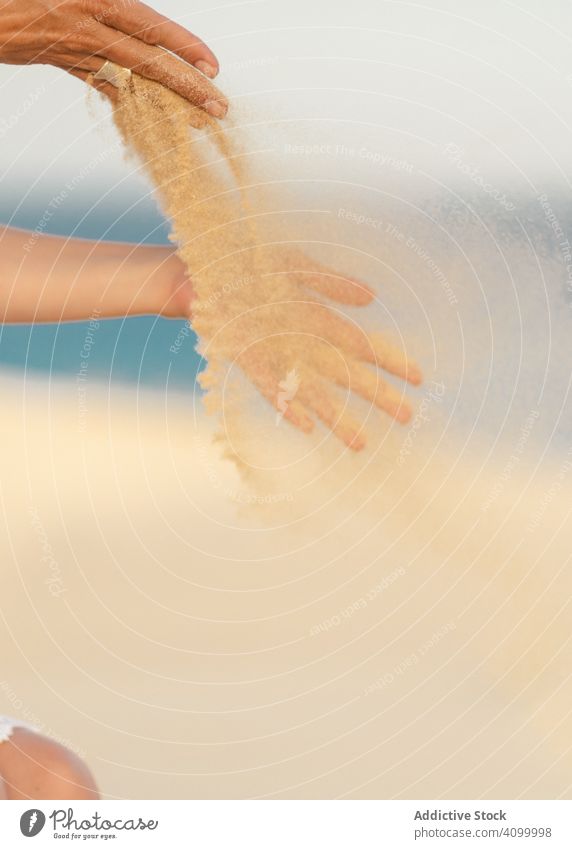 Frau, die Sand in den Händen in den Wind freigibt Seeküste Strand Armband Sommer Zubehör tropisch Urlaub Erwachsener schön sich[Akk] entspannen reisen Feiertag