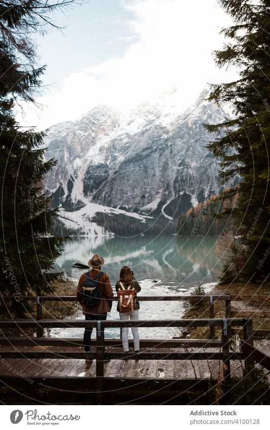 Ausruhendes Paar mit Blick auf See und Berge Berge u. Gebirge Kiefer Baum Wald Himmel Stehen hölzern Brücke lässig Natur Abenteuer Felsen Aktivität Landschaft