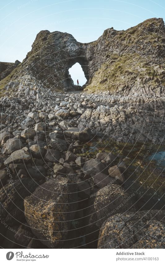 Frau steht in Felshöhle Felsen Höhle Klippe Saum Hafen Stein Natur Berge u. Gebirge erkunden Tourist Landschaft Wand Bodenerhebung Höhe antik Hügel Felsspitze