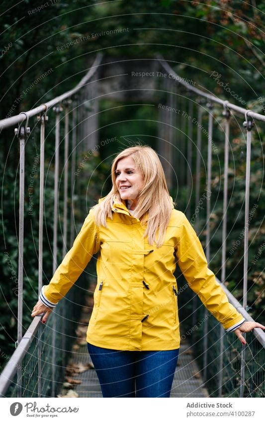 Fröhliche Touristin steht im Sommer auf Hängebrücke Frau Steg Wald heiter Urlaub Suspension Sommerzeit Tourismus erhängen reisen Reise Natur Abenteuer Park