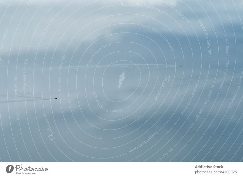 Kleines schnelles Flugzeug fliegt in bewölktem Himmel Geschwindigkeit Fluggerät wolkig reisen Verkehr Air Luftverkehr Cloud Fliege Transport Reise blau