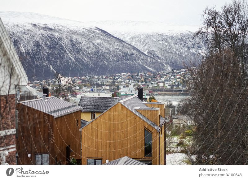 Wunderbare Kulisse der Winterstadt gegen verschneite Hochland in kalten bewölkten Wetter Großstadt Fjord Haus Architektur Vorberg Stadt malerisch Tourismus