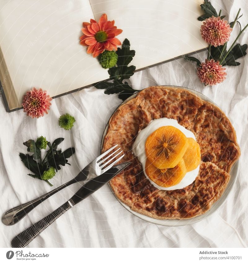 Crêpes mit Sahne und Kakipflaume Frucht Persimone Lebensmittel rötlich Dessert geschmackvoll Gabel Portion Messer Buch Blumen Scheibe lecker Teller Stoff