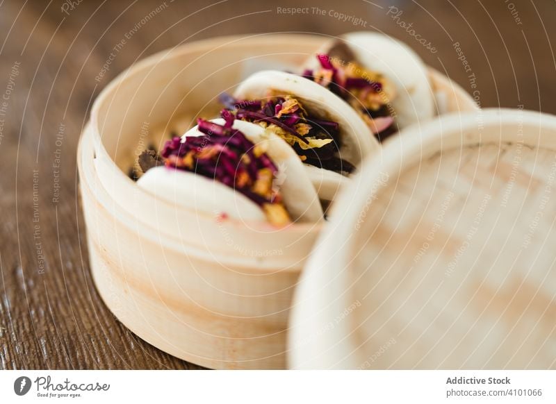 Traditionelle asiatische Dampfbrötchen im Bambusdampfer gedünstet Brötchen traditionell Brot Lebensmittel Snack Belegtes Brot Bao gua bao Küche Chinesisch