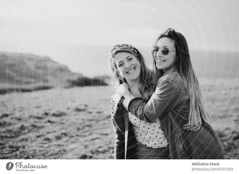 Stilvolle fröhliche Frauen auf grüner Wiese stehend Feld Glück Schwester Harmonie Landschaft Frühling Zusammensein Natur schließen reisen Tourismus Reise