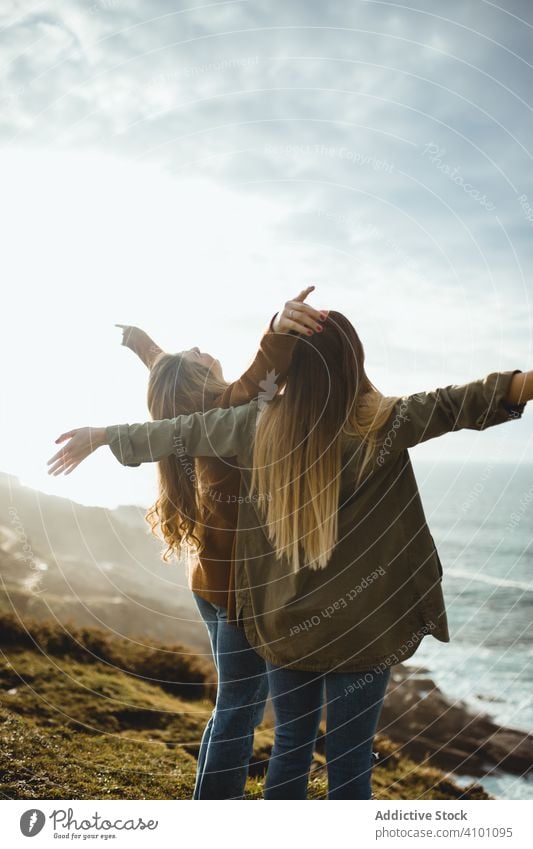 Glückliche weibliche Reisende genießen die Freiheit am Meer Frauen Seeküste Brise frisch fliegendes Haar Schwester stehen Harmonie Landschaft Zusammensein