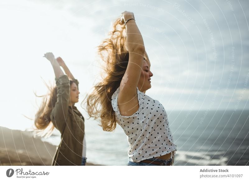 Glückliche weibliche Reisende genießen die Freiheit am Meer Frauen Seeküste Brise frisch fliegendes Haar Schwester stehen Harmonie Landschaft Zusammensein