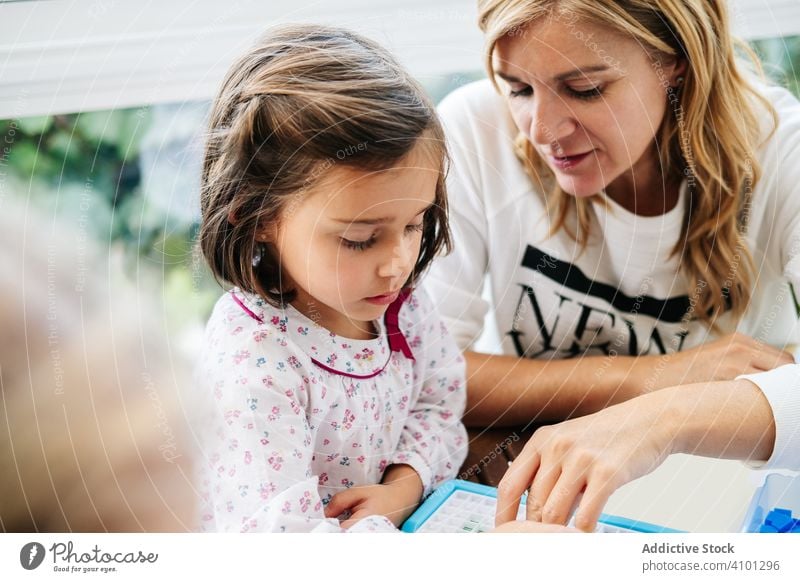 Frau spielt Brettspiel mit Tochter spielen Holzplatte Familie Spiel Mutter Zusammensein Spaß Glück Mädchen Tisch Spielfigur Kind Eltern Menschen Kindheit