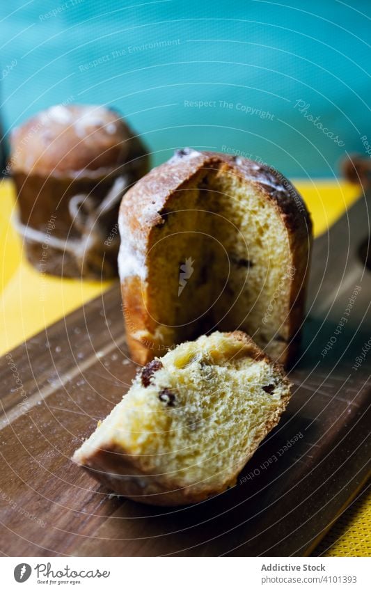 Traditioneller Panettone mit Rosinen auf Holzbrettchen Dessert traditionell Kuchen Spielfigur geschnitten Scheibe backen Brot Weihnachten Lebensmittel