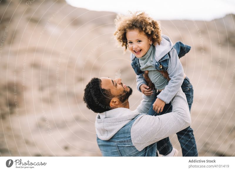 Ethnischer Vater spielt mit Kind am Boden Kleinkind spielen Spaß ruhen Sand Hügel Lächeln Eltern Glück heiter Lifestyle modern Natur Papa Mann horizontal Bonden