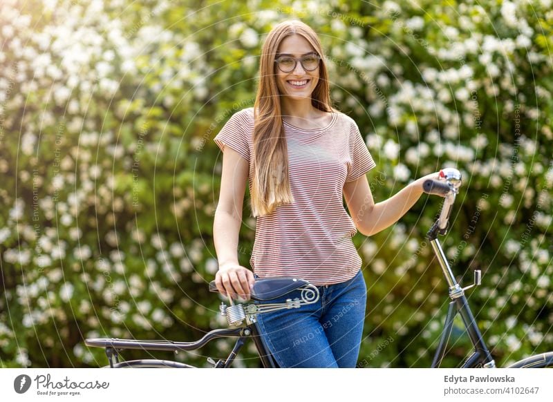 Junge Frau geht für eine Fahrradtour im Park aktiv in Bewegung Pendler Verkehr Zyklus Fahrradfahren Radfahren Gesundheit umweltfreundlich ökologisch genießend