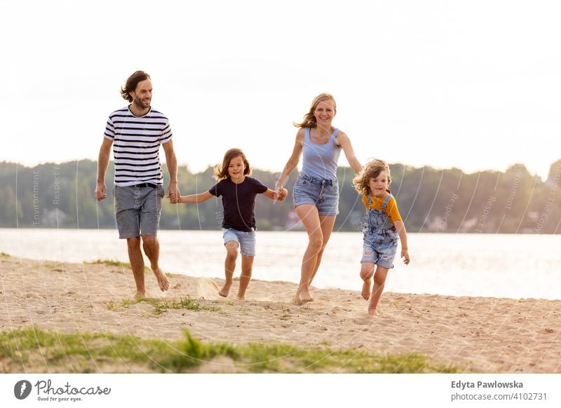 Junge Familie mit Spaß im Freien am Strand MEER See Feiertage Urlaub Natur Sommer Eltern Sohn Kinder Zusammensein Zusammengehörigkeitsgefühl Liebe Menschen