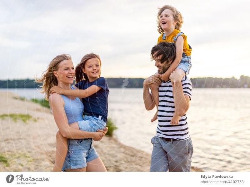 Junge Familie mit Spaß im Freien am Strand MEER See Feiertage Urlaub Natur Sommer Eltern Sohn Kinder Zusammensein Zusammengehörigkeitsgefühl Liebe Menschen