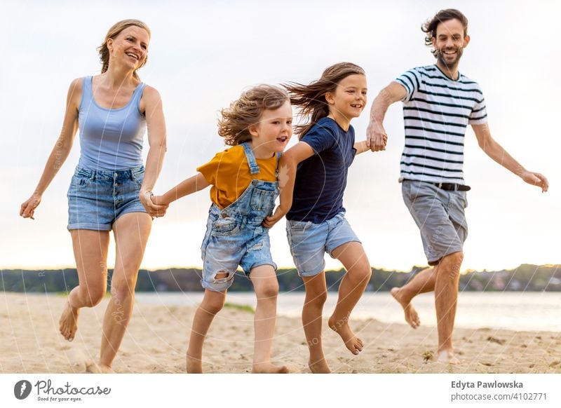 Junge Familie mit Spaß im Freien am Strand MEER See Feiertage Urlaub Natur Sommer Eltern Sohn Kinder Zusammensein Zusammengehörigkeitsgefühl Liebe Menschen