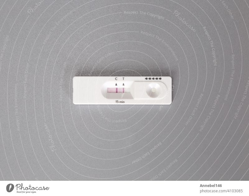 Positives Ergebnis des Coronavirus, Covid-19-Schnell-Selbsttest zu Hause auf grauem Hintergrund Ansicht von oben. Coronavirus, Gesundheit, Industriekonzept mit Kopierraum